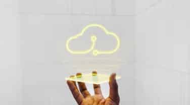 A man's hand is holding a cloud in front of it, showcasing the intersection of technology and global consulting.